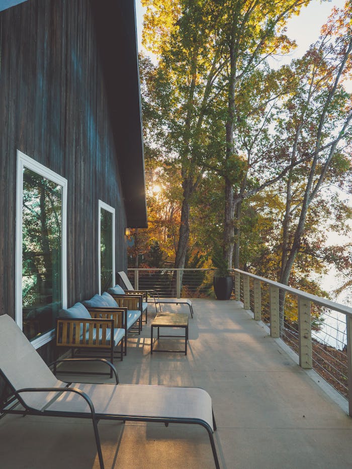 Serene outdoor patio with lounge chairs and a forest view, perfect for relaxation.